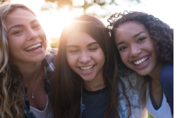 3 females smiling at the camera in article on toxic culture